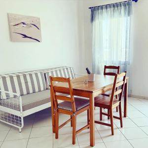 a living room with a table and chairs and a couch at Spanos Apartments in Agios Petros