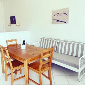 a wooden table and chairs next to a couch at Spanos Apartments in Agios Petros