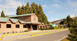 a building on the side of a street with trees at Hotel Bahia Redonda in El Calafate