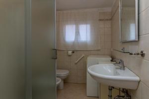 a bathroom with a sink and a toilet at Veneziacentopercento Ole Apartment in Venice