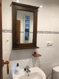 y baño con lavabo, espejo y aseo. en Apartamentos Rurales Xaranzana, en Las Morteras