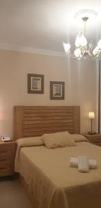 um quarto com uma cama grande e um lustre em Casa Rural Huerta Vallejo em Ronda