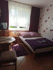 a small bedroom with a bed and a window at El Jan Pobierowo in Pobierowo