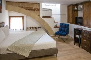 1 dormitorio con 1 cama grande y 1 silla azul en Aurelia Luxury - Piazza delle Erbe en Verona
