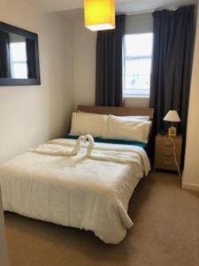 a bedroom with a white bed with a window at Flat 34 Fraser house apartment city centre apartment in Aberdeen