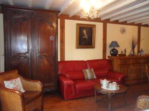 sala de estar con sofá rojo y mesa en Welcome, en Authuille