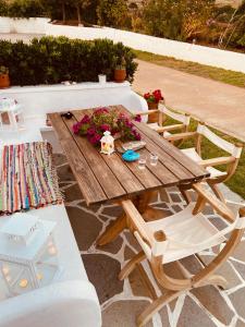 a wooden table and chairs with flowers on it at Spanos Apartments in Agios Petros
