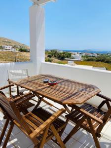 y balcón con mesa y sillas de madera. en Spanos Apartments, en Agios Petros