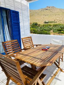 a wooden table and two chairs on a porch at Spanos Apartments in Agios Petros