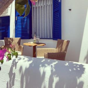 a table with chairs and a table with a glass at Spanos Apartments in Agios Petros