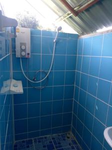 a blue tiled bathroom with a shower and a sink at Samoeng fishing park home stay in Samoeng