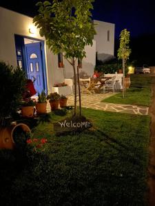 a yard with a blue door and a table with chairs at Spanos Apartments in Agios Petros