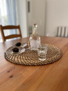 a bottle and a glass sitting on a table at Spanos Apartments in Agios Petros