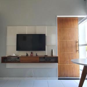 a living room with a flat screen tv on a wall at Encantos do Porto da Barra in Salvador