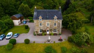 an aerial view of a large stone house with parked cars at Thistle House Guest House in Saint Catherines