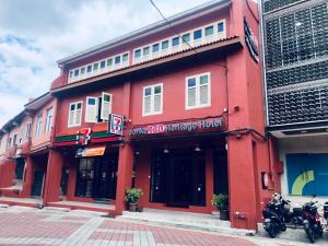 un edificio rosso con moto parcheggiate di fronte di JonkeRED Heritage Hotel a Malacca