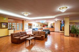 a large living room with couches and a kitchen at Hotel Villa Strassoldo "Ex Attianese Hotel Restaurant" in Cervignano del Friuli