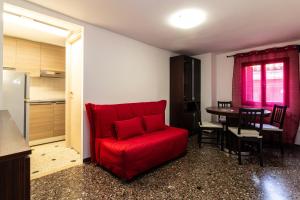 a red couch in a room with a table at Veneziacentopercento Ole Apartment in Venice