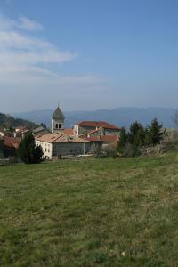 un campo de hierba con un edificio y una iglesia en Les Gîtes du Couvent en Ardèche - Gîte de groupe en Nozières