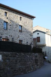 un edificio de piedra con una valla delante en Les Gîtes du Couvent en Ardèche - Gîte de groupe en Nozières