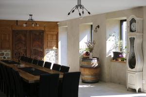 comedor con mesa grande y sillas negras en Les Gîtes du Couvent en Ardèche - Gîte de groupe en Nozières