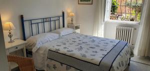 Schlafzimmer mit einem Bett mit blauem Kopfteil und einem Fenster in der Unterkunft LE ORCHIDEE già Lancillotto in Levanto