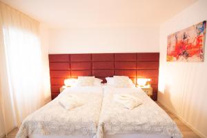 een slaapkamer met 2 bedden met witte dekens en kussens bij Letorina rooms and apartments with pool in Matulji