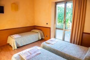 Filottrano的住宿－Hotel Ostello Settecolli Sport，酒店客房设有两张床和窗户。