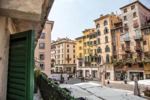 vistas a una calle con edificios y sombrillas en Aurelia Luxury - Piazza delle Erbe, en Verona