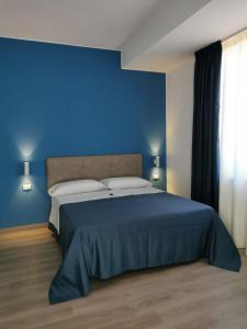 - une chambre bleue dotée d'un lit avec un mur bleu dans l'établissement La Terrazza degli Dei, à Buonvicino