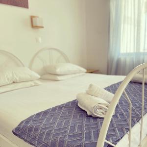 エイオス・ペトロスにあるSpanos Apartmentsのベッド1台(白いベッド2台、タオル付)