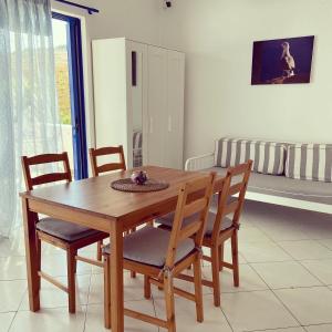 a wooden table and chairs in a living room at Spanos Apartments in Agios Petros