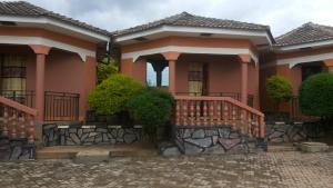 a pink house with a staircase in front of it at Hotel Delambiance in Koboko