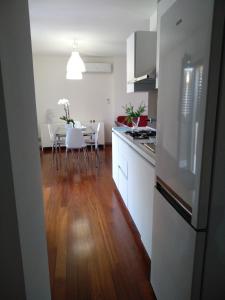 a kitchen with white cabinets and a table with white chairs at Biancaura sunlight in Comiso