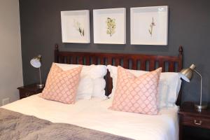 a bedroom with a bed with pink and white pillows at Heuglins Lodge in White River