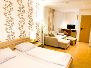 um quarto de hotel com duas camas e uma sala de estar em Hotel zur Loreley - Garni em Sankt Goar