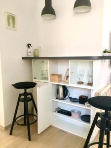a kitchen with white cabinets and two stools at Liberty Town Center Rooms in Dubrovnik