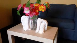 a vase of flowers on a table with towels at Apollo Inn - Cocoa in Cocoa