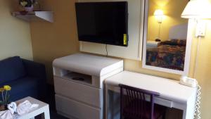 a room with a tv and a couch and a chair at Apollo Inn - Cocoa in Cocoa