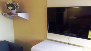 a large flat screen tv sitting on a wall at Apollo Inn - Cocoa in Cocoa