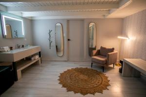 a bathroom with a sink and a chair and a mirror at Trópica Beach Hotel in San Juan