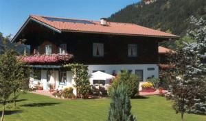 a large house with a red roof on a lawn at Landhaus Meran in Rauris