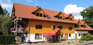a large yellow house with a red roof at Betzemühle 2 Bauernhof in Altenschlirf