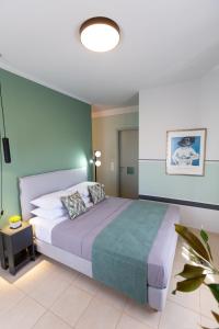 een slaapkamer met een bed en een groene muur bij Magnolia - Apartment in Kalamata in Kalamata