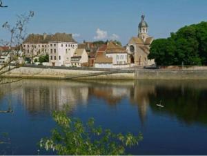 a town with a church and a lake with a building at Appartement Dulac in Seurre