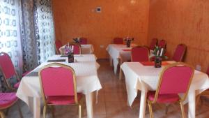 a row of tables in a room with pink chairs at Rock Shadow Hotel in Koboko