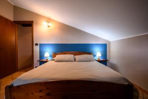 1 dormitorio con 1 cama grande y cabecero azul en Agriturismo L'Ciabot, en Paesana