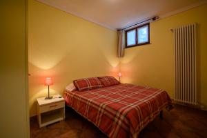 a small bedroom with a bed and a window at Agriturismo L'Ciabot in Paesana