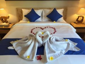 a bed with two swans made out of towels at Cahaya Guest House in Ubud
