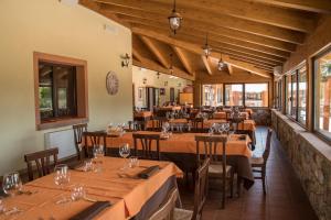 un restaurant avec des tables et des chaises en bois ainsi que des fenêtres dans l'établissement Agriturismo BioSila, à Acri